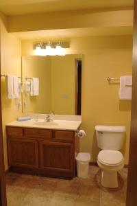 Un baño con lavabo, inodoro y espejo. en 2 Bedroom Duck Lake Condo, #107, en Eagle River