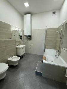 a bathroom with a tub and a toilet and a sink at V centru Znojma s vybavením pro děti a garáží pro kola in Znojmo