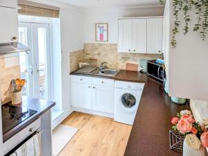 a kitchen with a sink and a washing machine at 7 Goodrington Lodge in Paignton