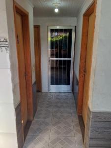 a hallway with two doors and a tile floor at Casa Água da Rocha in Itaguaí