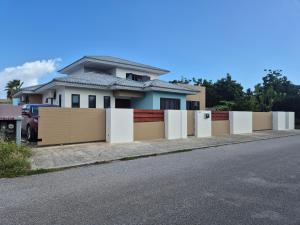a house with a fence on the side of the road at Sunflower-Lodge in Willemstad +1 photo