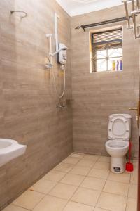 a bathroom with a shower and a toilet and a sink at Urban Bliss Residence in Bungoma +30 photos