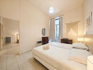a bedroom with a large white bed and a mirror at Viva Riviera Residence Marina Croisette in Cannes +4 photos