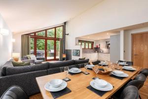 a dining room and living room with a wooden table at Glentress Forest Cabins - Forest Holidays in Peebles