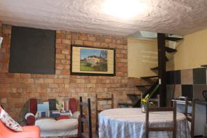 a room with a table and a brick wall at Pousada Gendra's in Imbituba