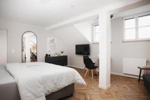 a white bedroom with a bed and a desk at DOM Apartment I - modern & zentral mit kostenfreiem Parkplatz in Fulda