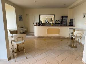 a kitchen with two tables and a counter with stools at Park Hotel Villamaria in Pavona