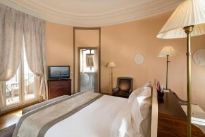 a bedroom with a large bed and a television at Le Cavendish in Cannes