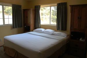 a bedroom with a large white bed with two windows at 2 Bedroom Accessible condo, #114 Wild Eagle Lodge in Eagle River