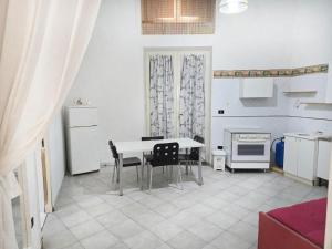 a kitchen with a table and chairs and a refrigerator at Home La Corte in SantʼAntimo