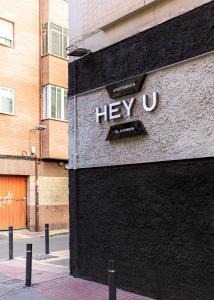 a sign on the side of a building at Apartamentos HEY U in Murcia