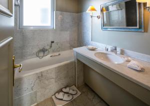 a bathroom with a sink and a tub and a mirror at Le Cavendish in Cannes