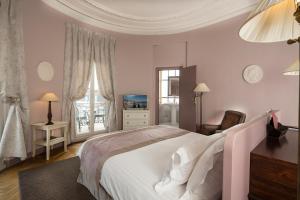 a bedroom with a large white bed and a window at Le Cavendish in Cannes