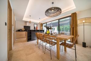 a kitchen and dining room with a wooden table and chairs at Stone villa with heated pool in Gordes in Gordes