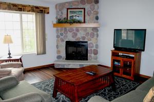 a living room with a fireplace and a tv at Wild Eagle Lodge, 2 bedroom 2nd floor condo, #216 in Eagle River