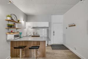a kitchen with white cabinets and a counter with stools at Initial 303 Québec in Quebec City