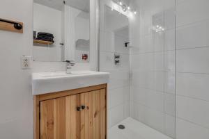 a white bathroom with a sink and a shower at Initial 303 Québec in Quebec City +12 photos