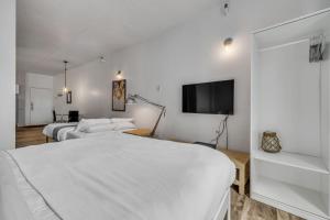 a bedroom with two beds and a flat screen tv at Initial 303 Québec in Quebec City