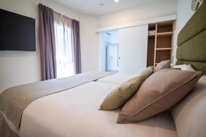Posteľ alebo postele v izbe v ubytovaní HL Miraflor Suites Hotel