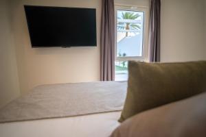 Televízia a/alebo spoločenská miestnosť v ubytovaní HL Miraflor Suites Hotel