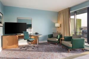 a hotel room with a desk and chairs and a television at Hilton Dublin Kilmainham in Dublin