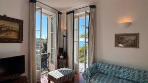 a living room with a couch and a sliding glass door at Il Veliero, Sea View in Bordighera