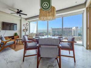 a dining room with a table and chairs and a large window at Luxury 3 BR Condo - Beach Access 1 Block Away in Bucerías