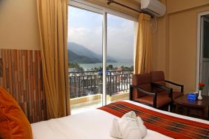 a hotel room with a bed and a large window at Pokhara Choice Inn in Pokhara