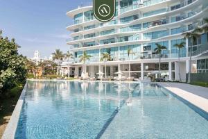 a swimming pool in front of a large building at Luxury 3 BR Condo - Beach Access 1 Block Away in Bucerías