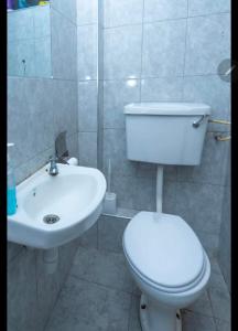een badkamer met een wit toilet en een wastafel bij tsavo roysambu in Nairobi +5 foto's