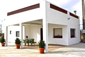 een wit huis met potplanten op een patio bij Casa Bassa de La Marquesa in Deltebre