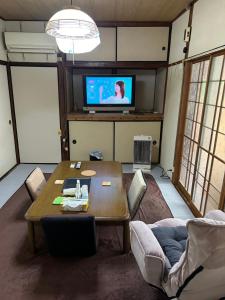 壹岐市一棟貸し民泊宿松山荘的配有桌子和平板电视的客厅