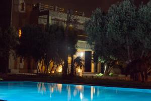 a building with a swimming pool at night at Riad AL MAKTOUB maison d'hotes écologique in Marrakech +36 photos