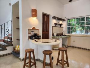 cocina con encimera y taburetes en una habitación en Playacar Family house private pool and surrounded by nature, en Playa del Carmen
