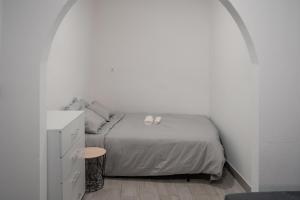 um quarto com uma cama com dois sapatos brancos em cima em AL-Bash em Elvas