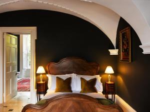 a bedroom with a large bed with two lamps at The Forest at Mount Congreve Gardens in Kilmeaden
