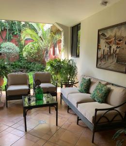 ein Wohnzimmer mit zwei Sofas und einem Tisch in der Unterkunft Hotel La Posada del Angel in San Salvador