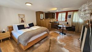 a bedroom with a large bed and a kitchen at Alpina Boutique Hotel Interlaken - Ringgenberg - Adults only ! in Ringgenberg