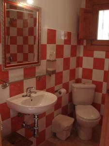 y baño con lavabo, aseo y espejo. en Hostal de la Luz en Cuenca