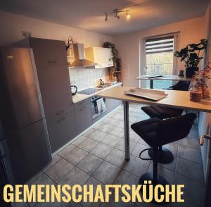 una cucina con tavolo e piano di lavoro di Quartier 3punkt0 alte Steigerbaude a Bad Gottleuba-Berggiesshübel
