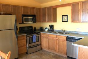 a kitchen with wooden cabinets and stainless steel appliances at 2 Bedroom Condo at Wild Eagle Lodge, #212 in Eagle River +24 photos