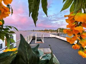 a dock with orange flowers on the side of a boat at Floating Hideaway- Coco de Mer in Ribnitz-Damgarten
