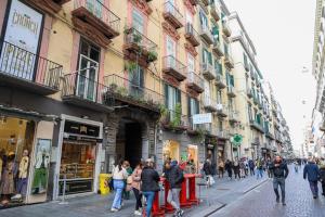 a group of people walking down a street with buildings at ToledoHomeNapoli in Naples
