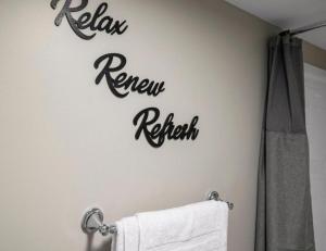 a bathroom with a sign that reads renew refresh on the wall at Upscale Studio in NY with Kitchen & Serene Setting in Congers