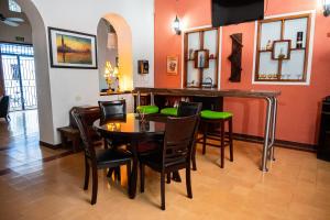 a dining room with a table and chairs and orange walls at Hotel La Palma Centro Histórico in Santa Marta