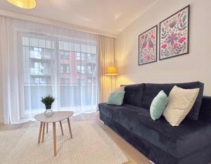 salon z czarną kanapą i stołem w obiekcie Apartamenty "Bastion Wałowa'' Q4Apartments w Gdańsku