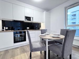 jadalnia ze stołem i krzesłami oraz kuchnia w obiekcie Apartamenty "Bastion Wałowa'' Q4Apartments w Gdańsku +37 zdjęć