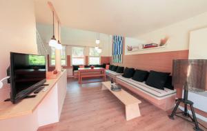 a living room with a couch and a tv at Le Lodge du Cap Ferret in Cap-Ferret