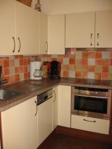 a kitchen with white cabinets and a stove top oven at HOSSEGOR PLAGE- Villa pour 4 personnes à 200m de la plage Sud in Hossegor