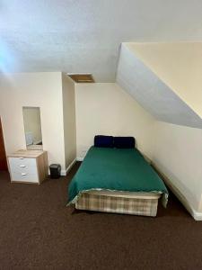 a bedroom with a bed with a green blanket at 55 Holgate Db Room Shared Bathroom & Kitchen in Nottingham